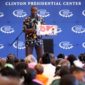 An educator reads to elementary students during a literacy program at the Clinton Center